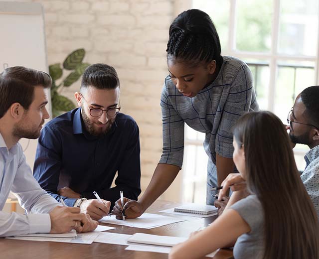 A group of people in business attire working at a table.