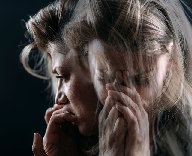 A person bowing their head while crying.