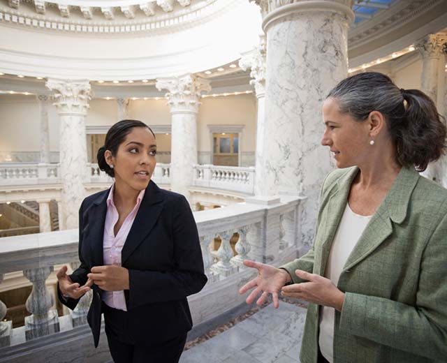 Two women talking in a state government house.