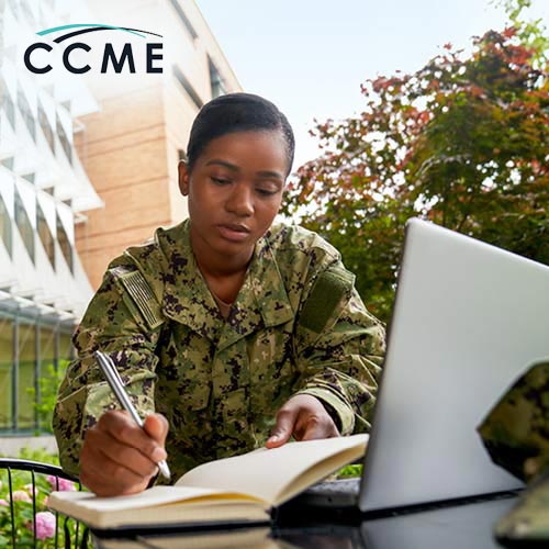 A woman in military fatigues studying outside