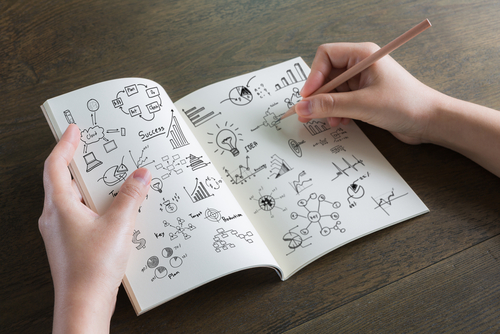 Hands with pencil and book write business graph on wood table