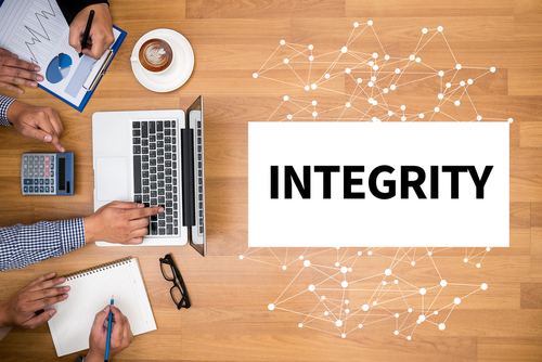 INTEGRITY   Ethics Loyalty Moral Motivation Business team hands at work with financial reports and a laptop