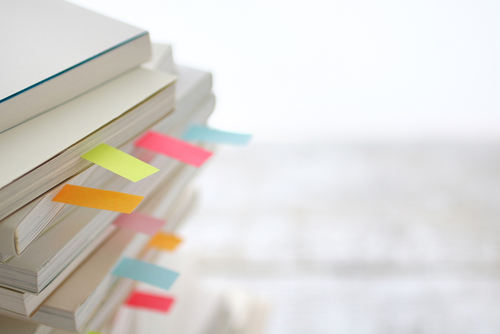 Colorful sticky notes sandwiched between books 