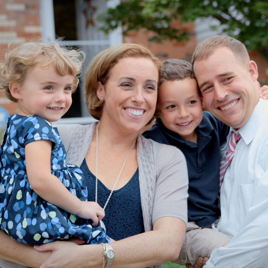 A UMGC student smiles joyfully with their family.