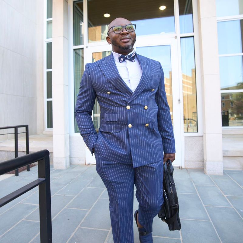 A person in a suit walking outside.