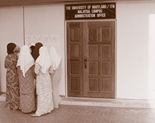 A group of people outside UMGC'S (then UMUC) Asia division. 