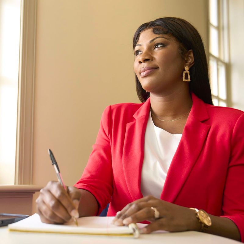 A person taking notes and subtly smiling.