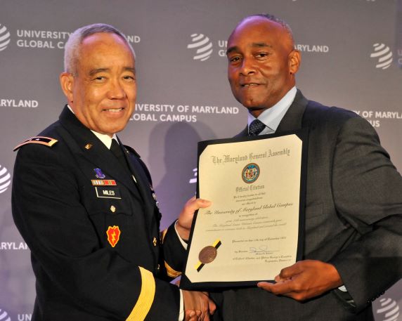 The Honorable Michael A. Jackson, Maryland state senator and chair of the Maryland Veterans Caucus, presents a citation from the Maryland General Assembly to Maj. Gen. Lloyd “Milo” Miles (U.S. Army, Ret.), UMGC’s senior vice president of Global Military Operations, in recognition of the university’s 75th anniversary.