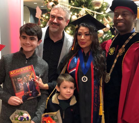 Graduate Lala Reynolds, who served as a social media ambassador, with her family and UMGC President Gregory Fowler