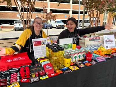 Two team members sitting as a table smiling.
