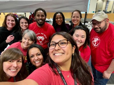 A group of 11 people smiling for a selfie.