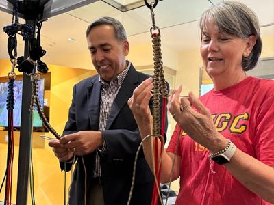 Two people smiling making paracord dog leashes.
