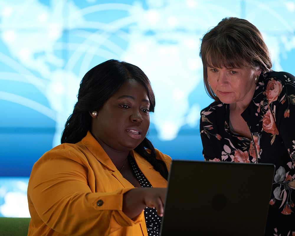 Two people looking at a laptop screen.