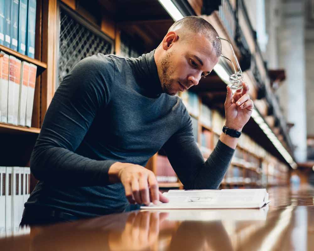 A person reading a book in a library.