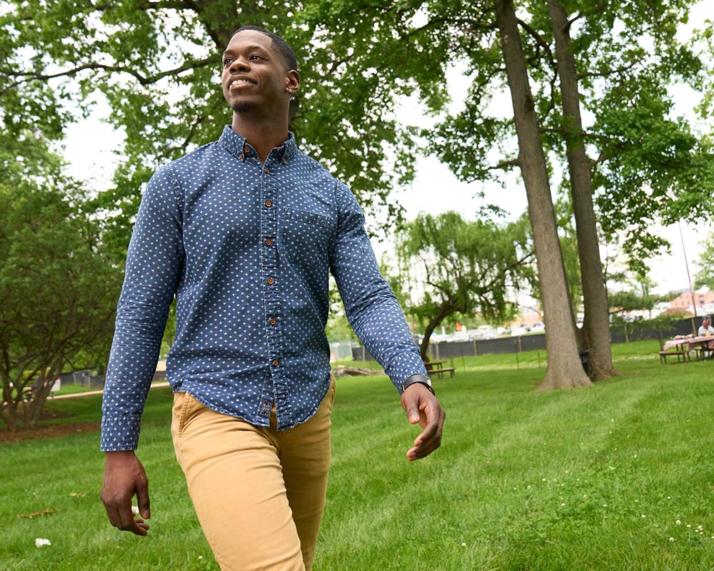 A person walking outside and smiling.