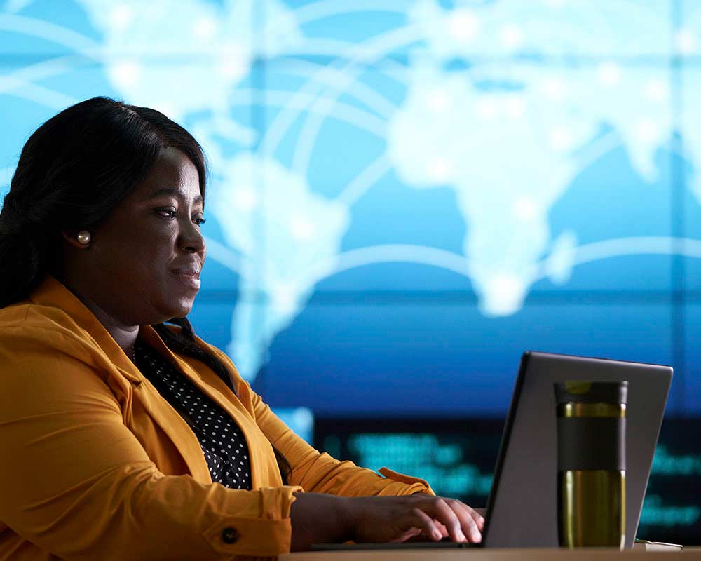 A UMGC student, who is pursuing a master’s degree in information assurance, is typing something on a laptop. 