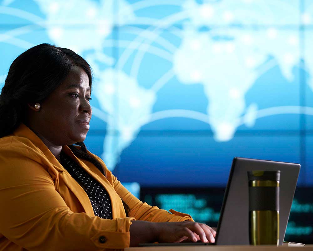 A UMGC student, who is pursuing a master’s degree in information assurance, is typing something on a laptop. 