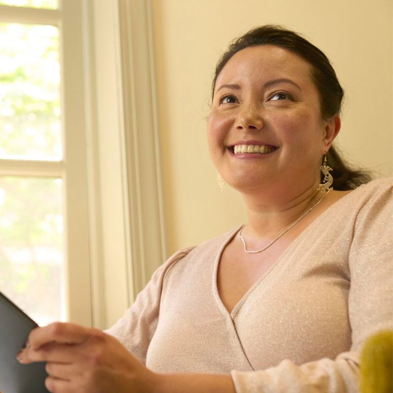 A person next to a window smiling. 