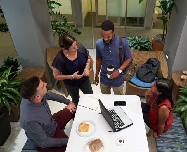 Students sitting around a table discussing a project.